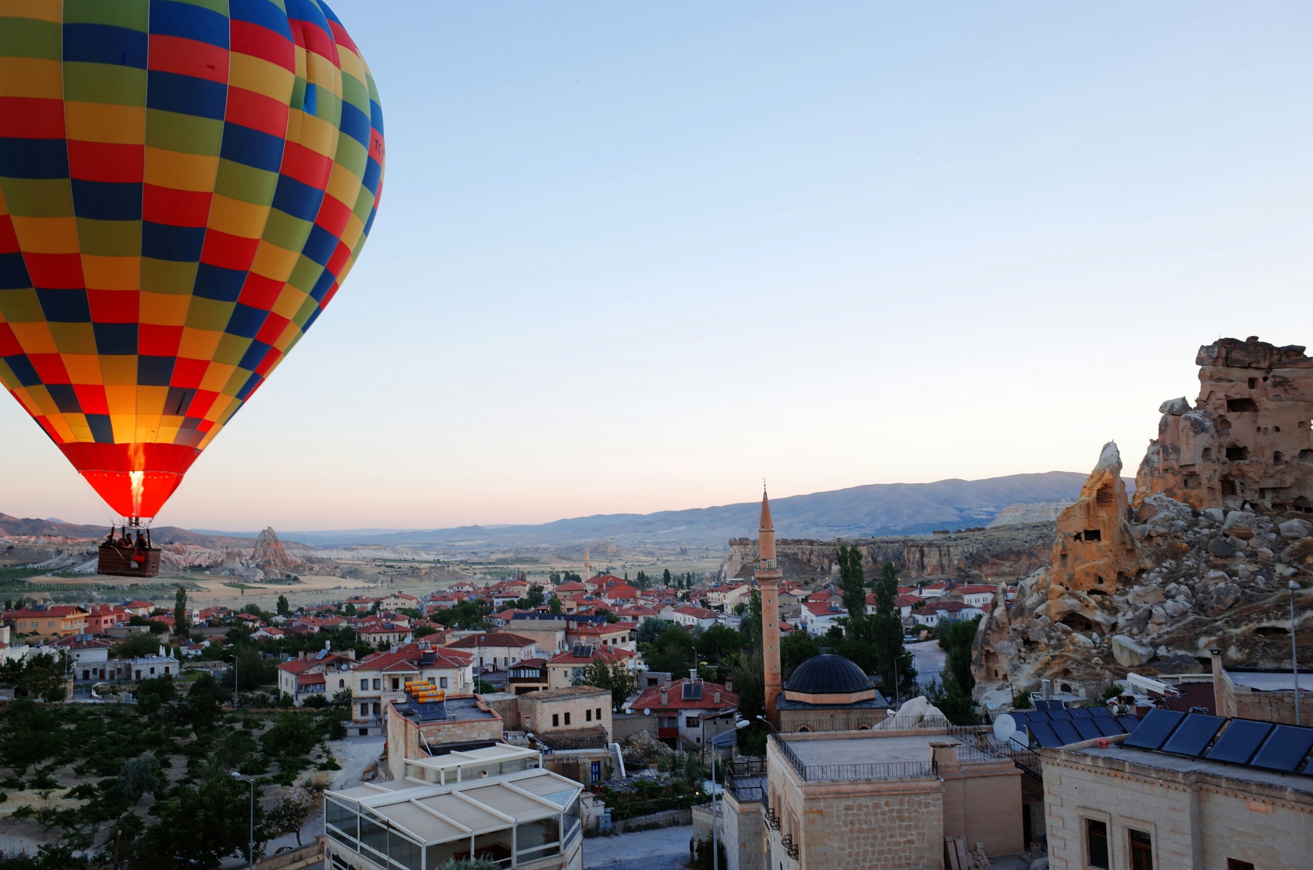 Hot air balloon over Göreme town at dawn